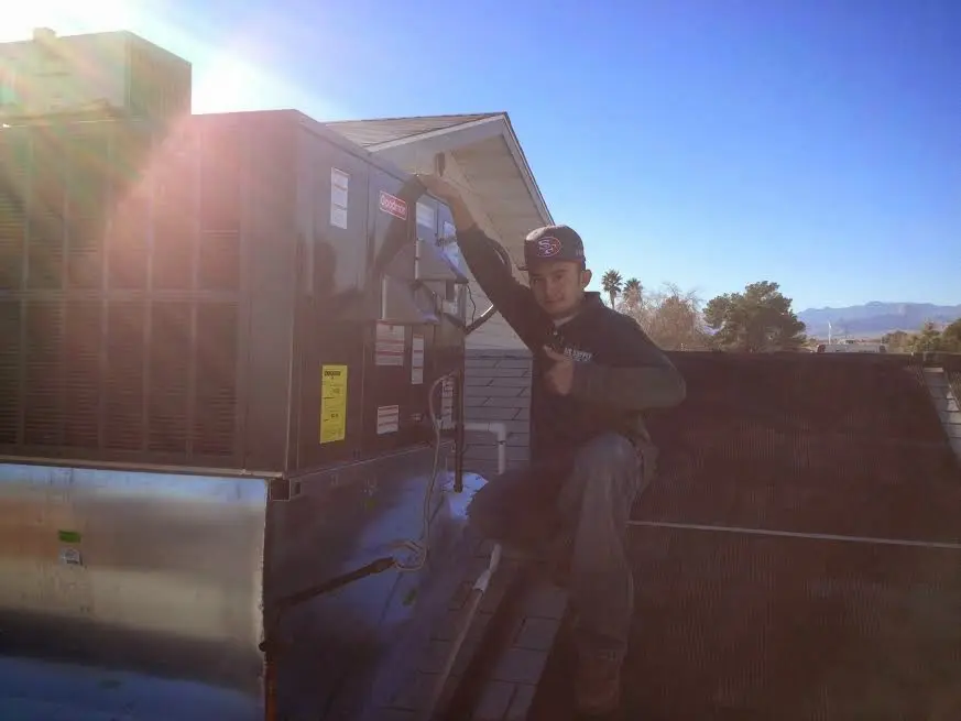 HVAC technician performing Air Duct Cleaning on a rooftop unit in Mehlville